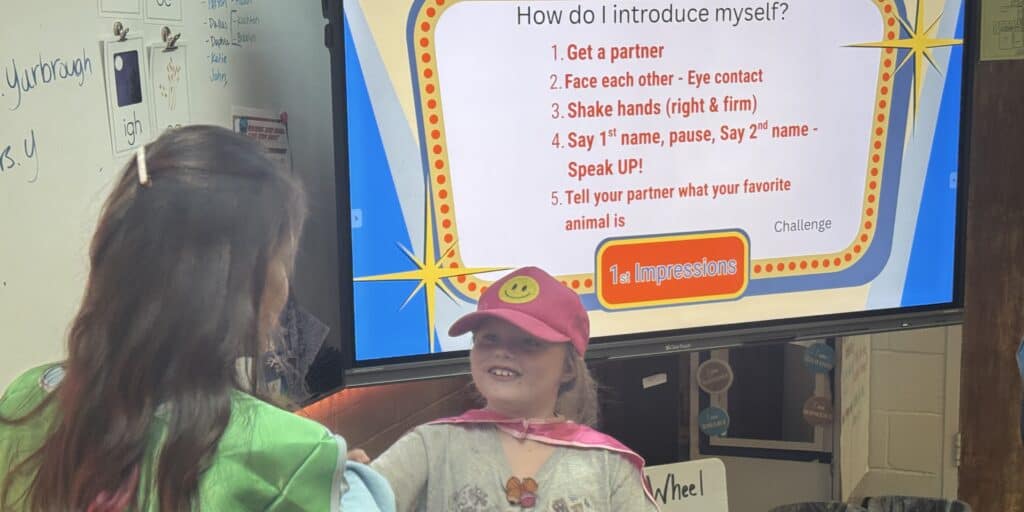 Ila Elementary School second grader Parker Sisk shakes hands with Melissa Yarbrough